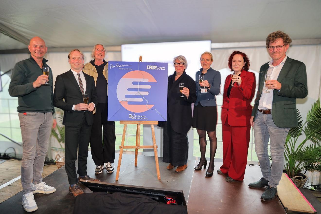 Op de foto proosten bestuurders, burgemeester en coördinatoren met alcoholvrije bubbels op de samenwerking Op de foto proosten bestuurders, burgemeester en coördinatoren met alcoholvrije bubbels op de samenwerking